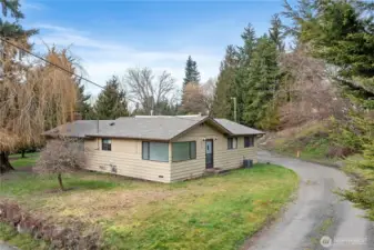 Single-level home set above the road, offering privacy and a peaceful, tree-lined setting
