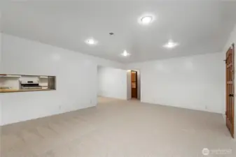 Flexible living space with kitchen pass-through and expansive wall area ideal for furniture placement or future design changes.