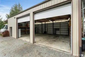 12x12 roll up doors with high ceilings, durable concrete floor, and ample room for equipment, vehicles, or projects.