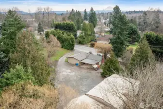 Elevated aerial showcasing the generous lot, surrounding greenery, and convenient access to nearby roads and amenities.