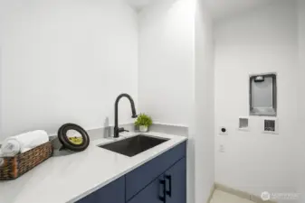 Upstairs laundry room with additional storage and sink.