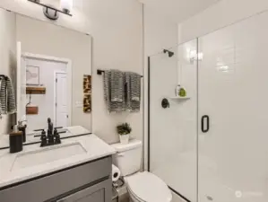 Main floor bathroom with walk in shower   photo of another model home, finishes may vary. For illustrative purposes only.