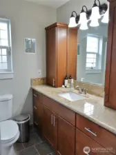 Downstairs Bathroom w/ tile floors and slab granite counters.