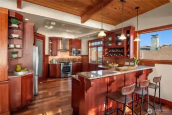 Rich cabinetry, granite counters, and stainless appliances define this warm and inviting kitchen, complete with a breakfast bar and custom wine storage.