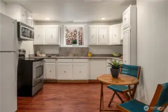 Mother-in-law kitchen offers a fully equipped space with classic white cabinetry, stainless appliances, and dining area - perfect for guests or extended living.