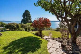 A stone pathway winds through the lush yard, leading to a private bluff-top perch where you can take in sweeping views of Vashon, the Sound and the Olympics!