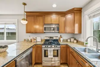 Modern kitchen with stainless appliances and warm finishes.