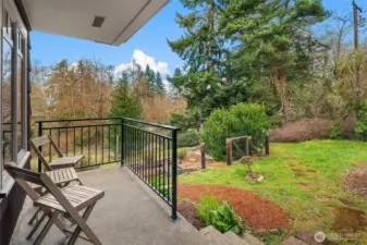 The front porch overlooks a terraced, fenced veggie and berry garden with garden shed.