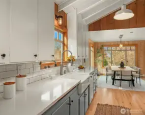 Updated kitchen with quartz counter tops, farmhouse sink, vaulted ceilings and wood floors.