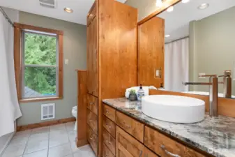 The upper full bath is also spacious and has a large ceramic vessel sink on the granite countertop. There is an abundance of cabinet storage space.