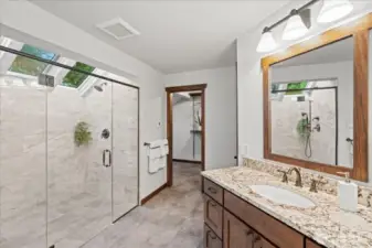 The primary bath features a no curb walk-in shower with dual shower heads