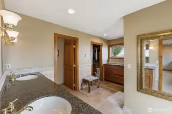 Double vanity and large walk in closet with built in wooden shelves and closet system.
