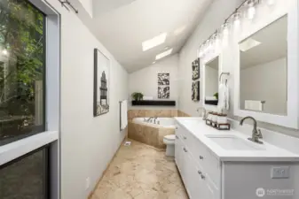 Main level full bath off primary bedroom features double sinks and a huge soaking tub.