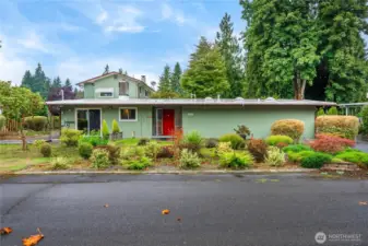 Lush curb appeal welcomes you home with vibrant landscaping and charming details