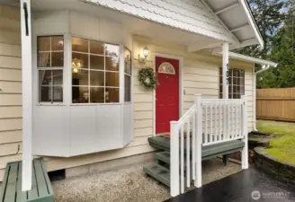Charming covered entry with built-in bench. Approaching the home, it's clear the owners have meticulously cared for the home and surrounding property.