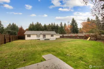 Expansive, fully fenced back yard perfect for play, gardening, or entertaining.