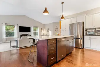 Pendant lighting over large kitchen island with stone countertops