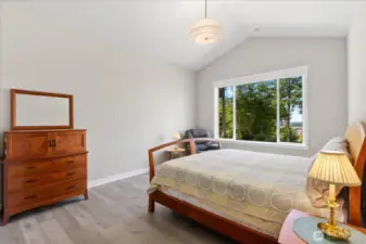 Primary bedroom features automated  blackout shades and cathedral ceilings.