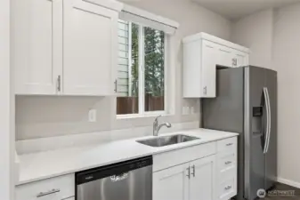 Modern kitchen featuring quartz countertops, stainless steel appliances, and ample cabinetry.