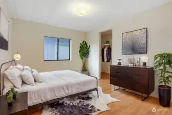 2nd bedroom with a walk in closet and laminate flooring.  Virtually staged photo