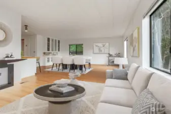 Formal living room with laminate flooring, western exposure and opens to kitchen with eating bar and dining room.  Virtually staged photo