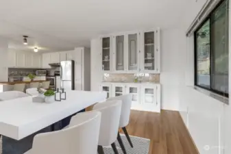 Formal dining room with laminate flooring and a built in hutch,  opens to the kitchen eating bar and living room.  Virtually staged photo