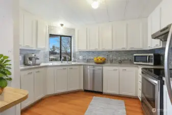 Updated kitchen with laminate flooring, refaced cabinets, stainless appliances and an eating bar.