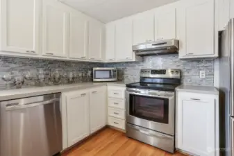 Updated kitchen with laminate flooring, refaced cabinets, stainless appliances and an eating bar.