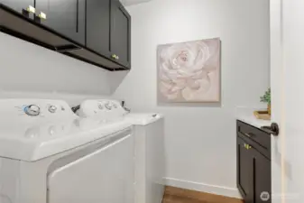 Functional laundry room with updated cabinets and quartz counter tops.