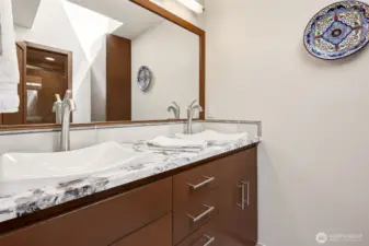 Full guest bathroom on upper level with heated floors under Travertine tile.