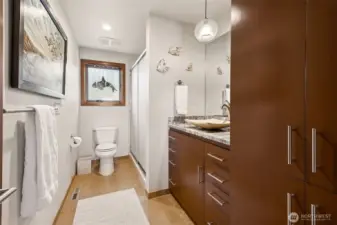 Bathroom on lower level features granite countertops & backsplash with above counter Travertine  sink and heated, Travertine floors