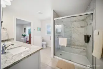 Shared bath area with a big shower and porcelain tile surround.
