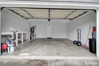 Spacious 2 car garage with storage shelving.
