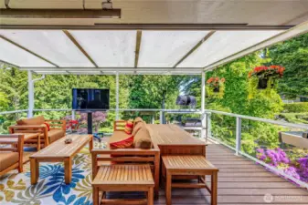 Just off the kitchen and dining area, a spacious Trex-style deck offers the perfect blend of open-air and covered comfort—ideal for year-round entertaining, relaxing, or even enjoying an outdoor movie night under the stars