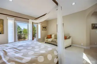 The main-level primary ensuite with private 5-piece bath, walk-in closet and private balcony with mountain views.