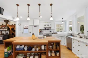 Amazing kitchen with so much to love. Island has power and storage galore with a butcher block top. All plliacnes stay and the antique cook stove on the far left is in the parlor just off the kitchen.
