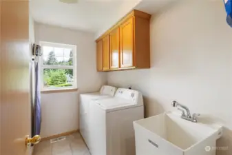 Utility room with storage cabinets, utility sink and a window!