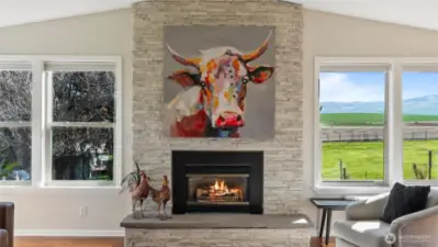 Stately stone-wrapped gas fireplace and hearth.