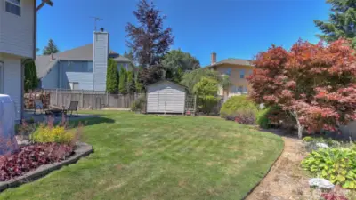Enjoy the coral bells, hardy fuchsia, varied Japanese maple trees, clematis, blue bells, hostas and candy tuft throughout this park-like backyard.