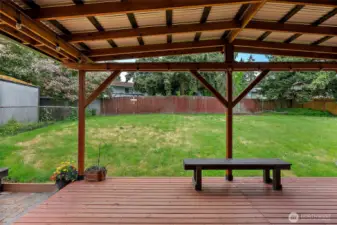 Covered deck with overhead lighting and bench seating—perfect for relaxing or hosting guests in your private fully fenced backyard.