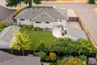 Fully fenced rear yard has large sunny patio, easy-care turf and lovely mature landscape. RV parking in upper right corner (with plug), 120 sf studio/office right of patio, 200 sf workshop at left.