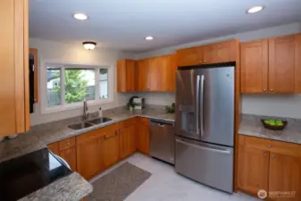 Well laid out kitchen features recessed task lighting, stainless appliances, back yard views and great granite counter workspace.