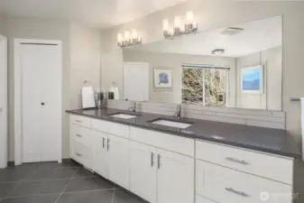 The primary suite with a spa-inspired bath: freestanding modern tub, dual shower, & generous closets.