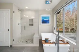 The primary suite with a spa-inspired bath: freestanding modern tub, dual shower, & generous closets.