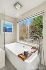 The primary suite with a spa-inspired bath: freestanding modern tub, dual shower, & generous closets.