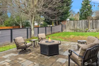 The private fully fenced 8,349sf  CORNER LOT with mature landscaping and a custom paver patio—ideal for PLAY, pets, and outdoor ENTERTAINING.
