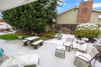 Of course it snows on picture day, but there is a concrete patio area, sweet patches of lush grass, and lots of mature landscaping- camelias, hellebore, hydrangea, roses and more.  On the left of the home, not pictured, is a level spot, great for gardening.