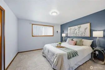 Comfortable primary bedroom with soft natural light, new carpet, and an easy-access sliding door closet.