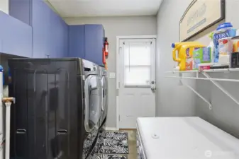 Convenient laundry room off the kitchen doubles as a mudroom, offering easy access to the outdoors.