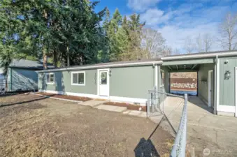 The covered breezeway between the home and garage offers ample space for a cozy sitting area, providing shelter from the elements.